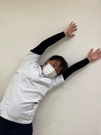 さらに深く側屈するストレッチを行う施術者