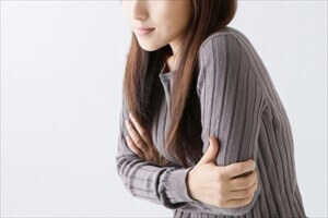 寒さに肩をすくめる女性