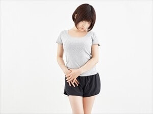 股関節の痛みに悩む女性が立っている様子