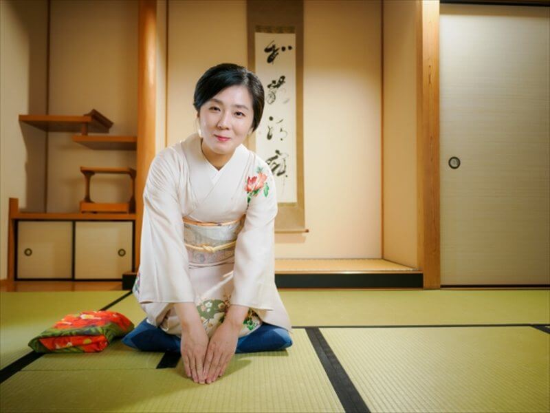 畳の上で正座をしている和装の女性