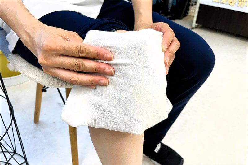 タオルで包んだ保冷材を膝に当てて冷却している様子