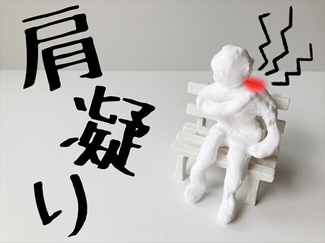 肩こりを抱えてベンチに座る人形のイラスト