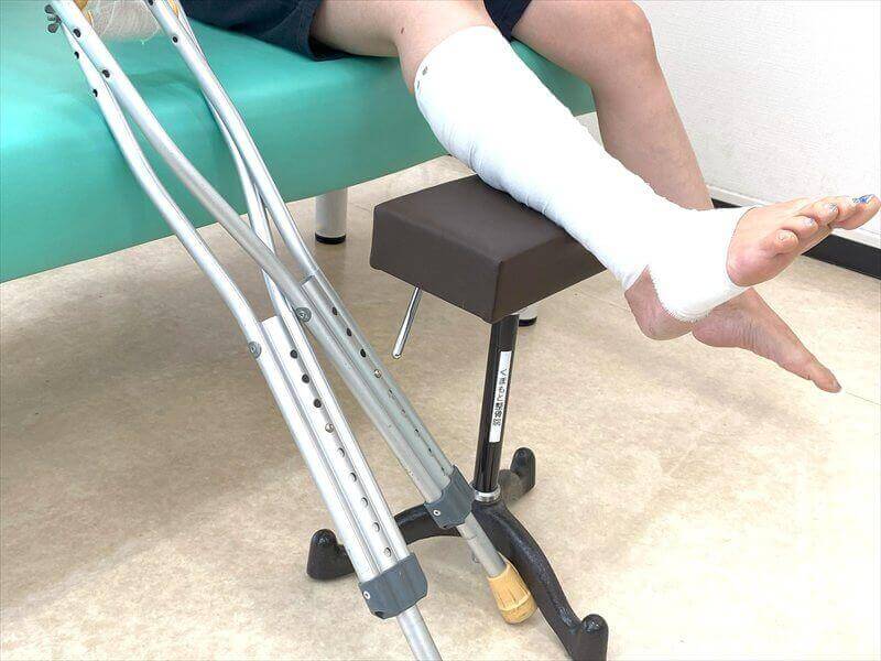 取手市くまもと整骨院で足の怪我に対する整骨施術を受ける様子(松葉杖と固定)