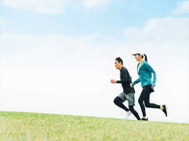草原を並んで走る男女のランナー
