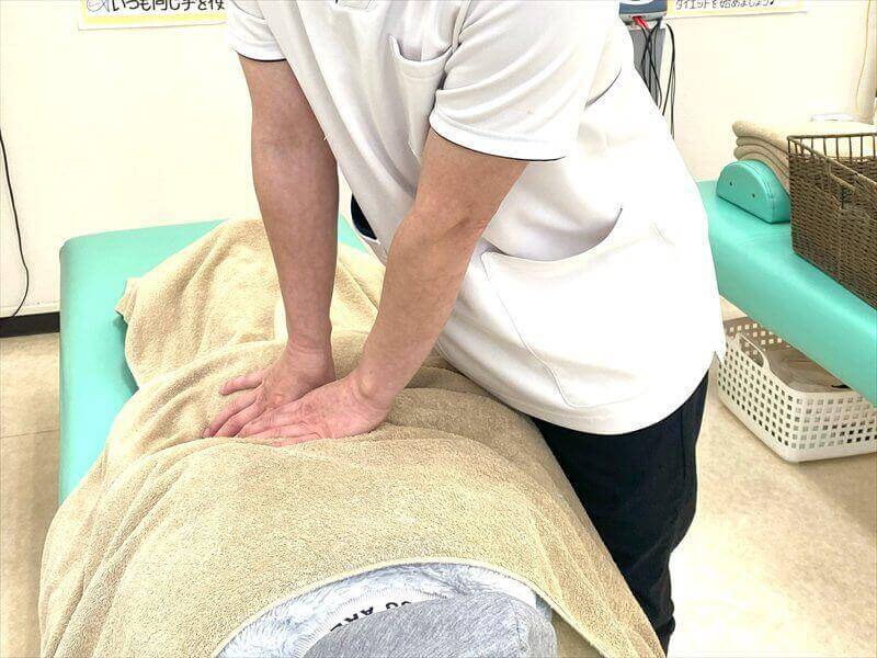 取手市くまもと整骨院で行う延長マッサージの様子(背中への手技施術)