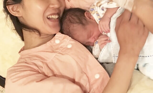 赤ちゃんを抱く産後の母親の写真
