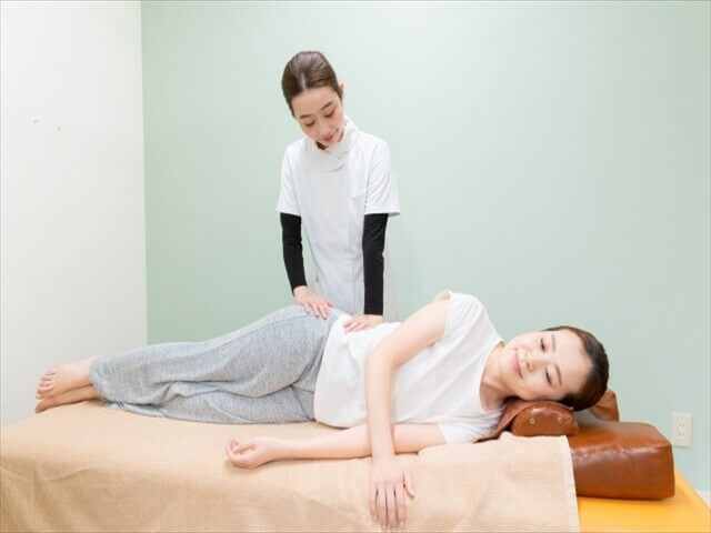 骨盤矯正を受ける女性と施術するスタッフ