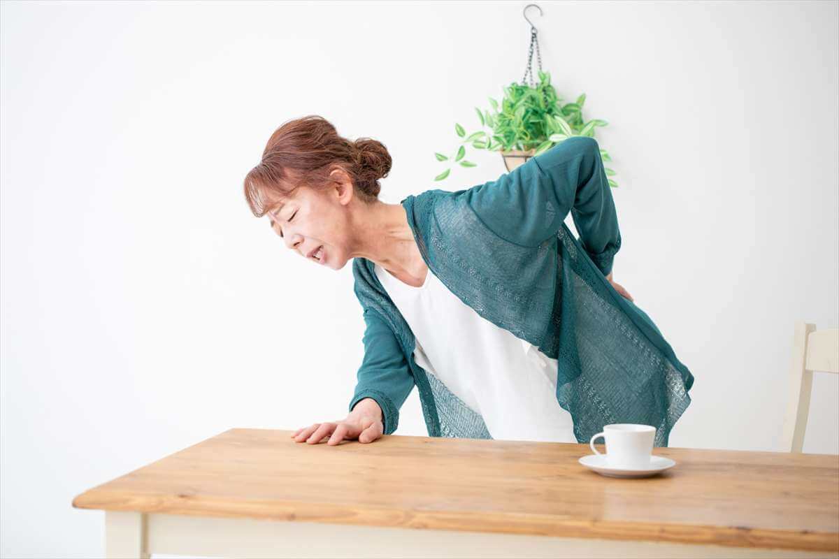 土日や祝日に突然起こる腰の痛みで動けなくなった女性のイメージ