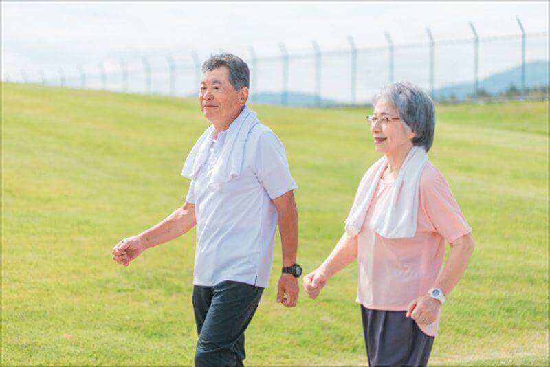 笑顔で並んで歩くシニア夫婦