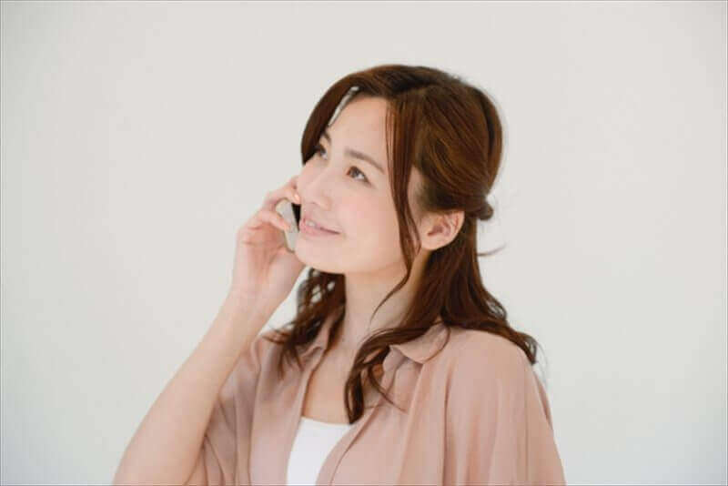 保険適用について電話で問い合わせをする女性