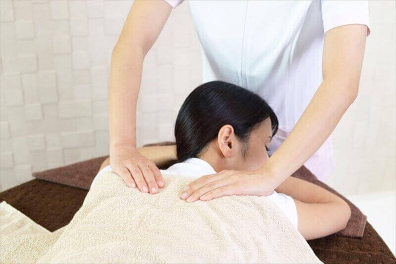 交通事故後の肩こりや体の不調に整体マッサージを行う様子