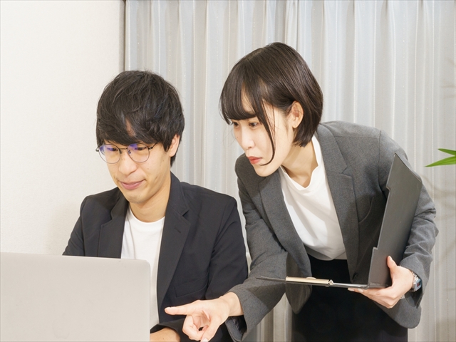 パソコンに向かって仕事をする男性と女性